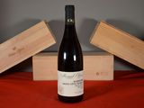 a bottle of wine sitting on a table next to two wooden boxes