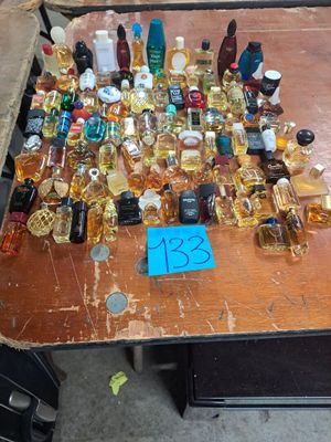 many bottles of perfume sitting on a table with a price tag