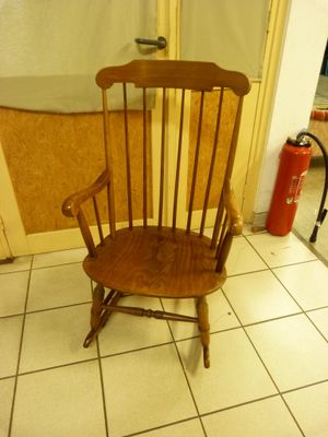 a wooden chair that is sitting on a tile floor