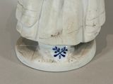 a white statue of a woman with a blue flower on it