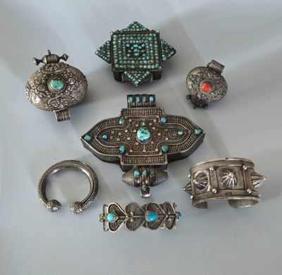 Plusieurs bijoux en argent et en turquoise sont exposés sur un fond blanc