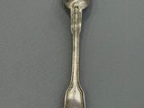 silver spoon with a heart shaped handle on a gray surface