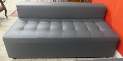 grey leather sofa in front of a red wall in a living room