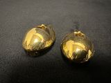 two gold bells are sitting on a black surface