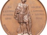 bronze medal of a man with a dog on a pedestal