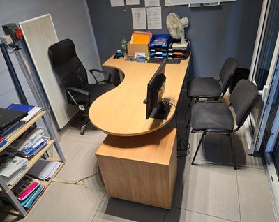 un bureau avec un ordinateur et une chaise dans une pièce