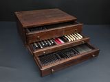 a wooden box with knives and spoons in it