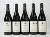 six bottles of red wine are lined up on a white surface