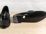 a pair of black shoes sitting on top of a wooden table