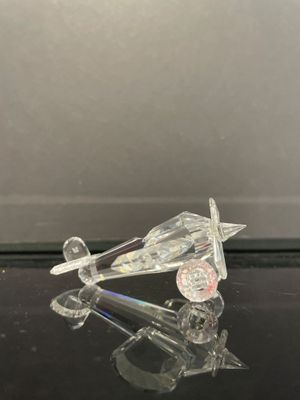 un objet en verre transparent posé sur une surface noire