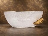 un saladier en verre avec une cuillère en bois posé sur une table