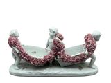 une figurine représentant deux personnes dans un bateau, décorée de roses
