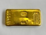 a gold bar on a white surface