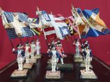 a group of figurines of soldiers holding flags on a table
