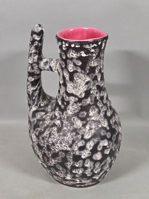 a black and white vase with a pink handle
