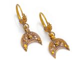 a pair of gold earrings with yellow crystals and a crescent