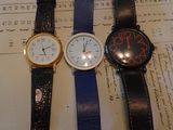 trois montres posées sur un bout de papier sur lequel il y a des inscriptions