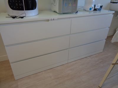 une commode blanche sur laquelle est posé un micro-ondes