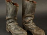 an old pair of brown boots with a black background
