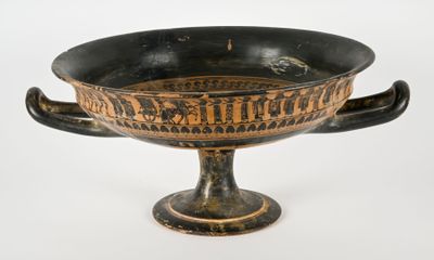 a black and gold bowl with a handle on it