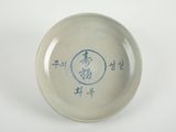 un petit bol sur lequel figure une inscription, posé sur une table