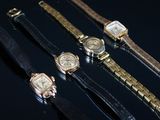 Plusieurs montres sont alignées les unes à côté des autres sur une surface noire