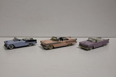 Quatre petites voitures sont alignées sur une surface blanche