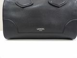 a close up of a black handbag on a white surface