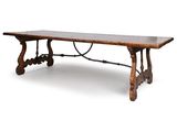 une vieille table en bois avec des pieds en fer forgé et un plateau en bois
