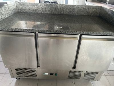 un meuble de cuisine en acier inoxydable à deux portes, avec un plan de travail en granit