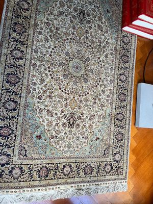un tapis posé par terre, à côté d'une lampe et d'un livre