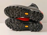 two pairs of black shoes with orange soles on a white surface