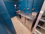 a kitchen with blue tiles and stainless steel counter tops