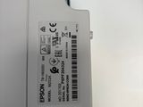 a close up of a white electronic device with a barcode on it