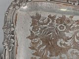a silver tray with a floral design on it