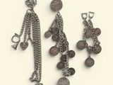 two pairs of earrings with coins hanging from them on a white surface