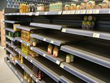 many empty shelves in a grocery store with canned food on them