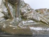 a bronze statue of a dog sitting on a rock