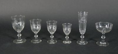 six glass goblets are lined up in a row on a black surface