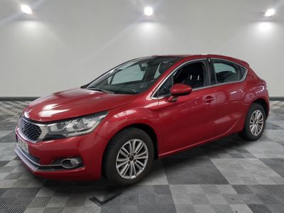 une voiture rouge est garée sur le sol en damier d'un garage