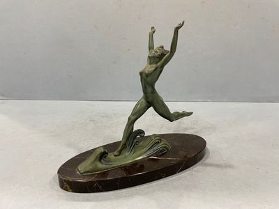 bronze sculpture of a woman jumping on a surfboard on a marble base