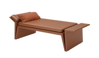 une banquette en cuir marron surmontée d'un coussin marron