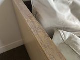 a bed with a white blanket and a wooden headboard