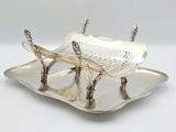 une assiette en argent sur laquelle est représenté un poisson, sur un fond blanc