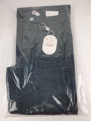 un pantalon noir pour homme dans un sac en plastique posé sur une surface blanche