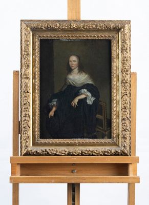 portrait d'une femme en robe noire, assise devant un chevalet en bois