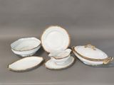 an image of a group of white and gold china dishes