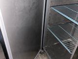 a refrigerator that is open in the corner of a kitchen