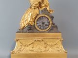 une horloge en or surmontée d'une statue
