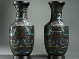 pair of black vases with colorful designs on them sitting on a table